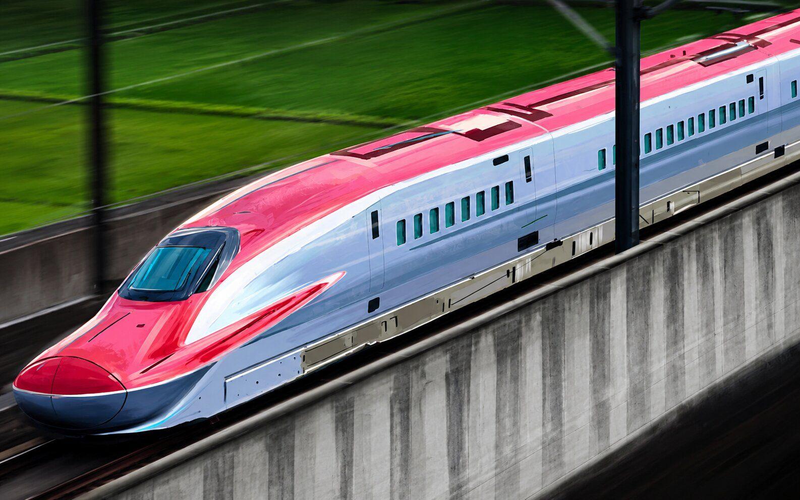 A red and silver high-speed train moves quickly on elevated tracks.