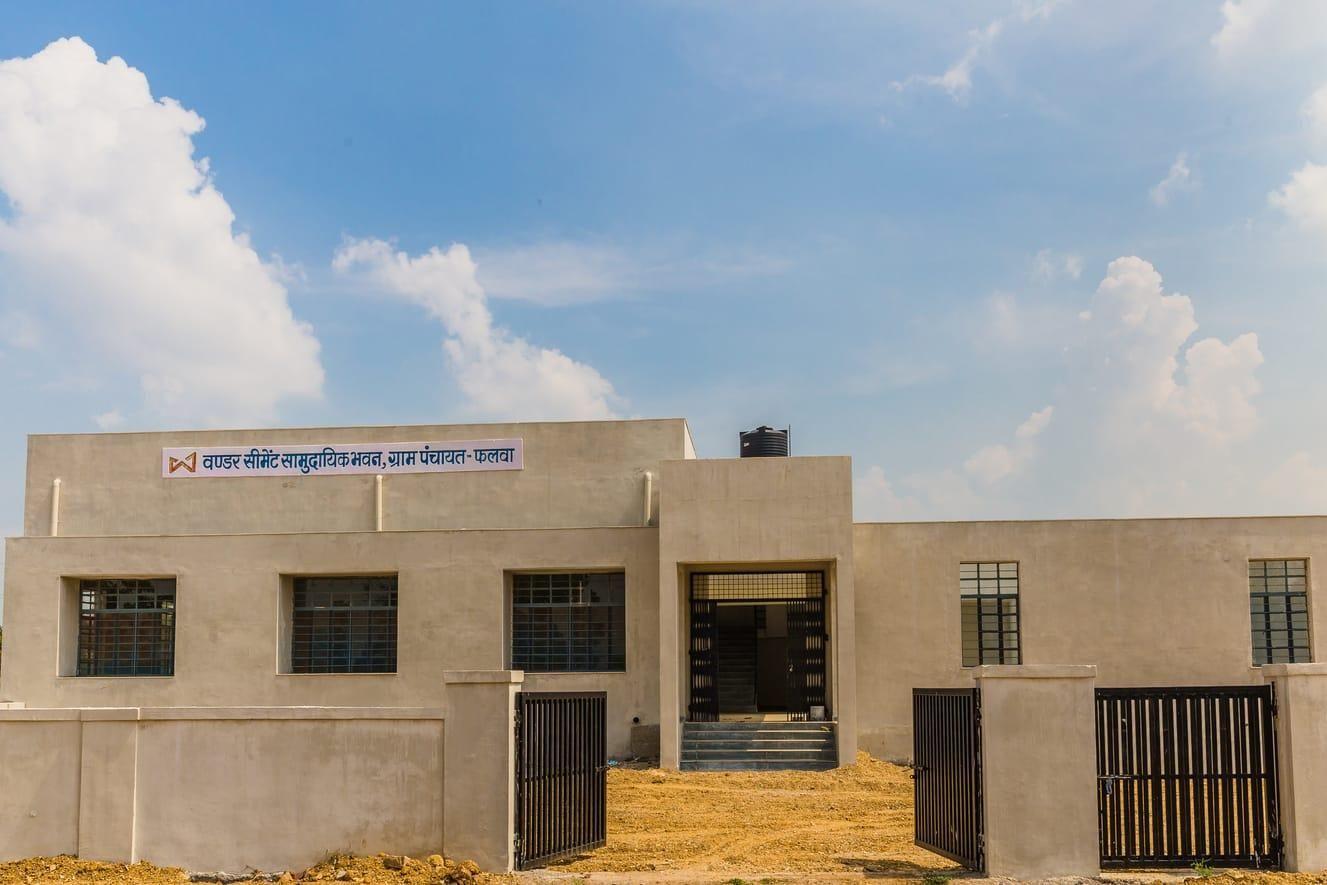 Modern institutional building with 'Shri Ramanuja Sanskrit Vidyalaya' sign under a blue sky.