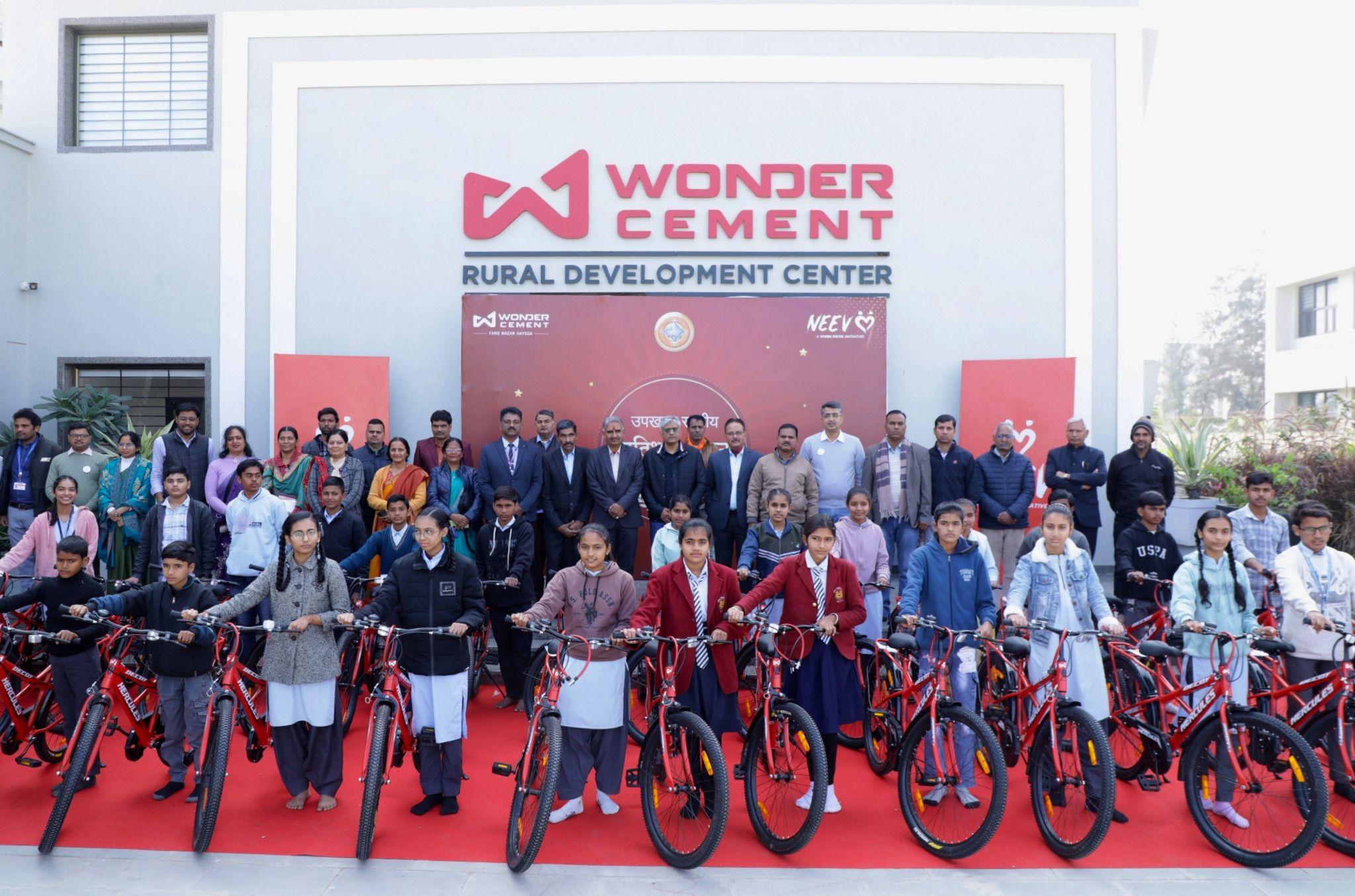 Students receive red bicycles in front of the Wonder Cement Rural Development Center.