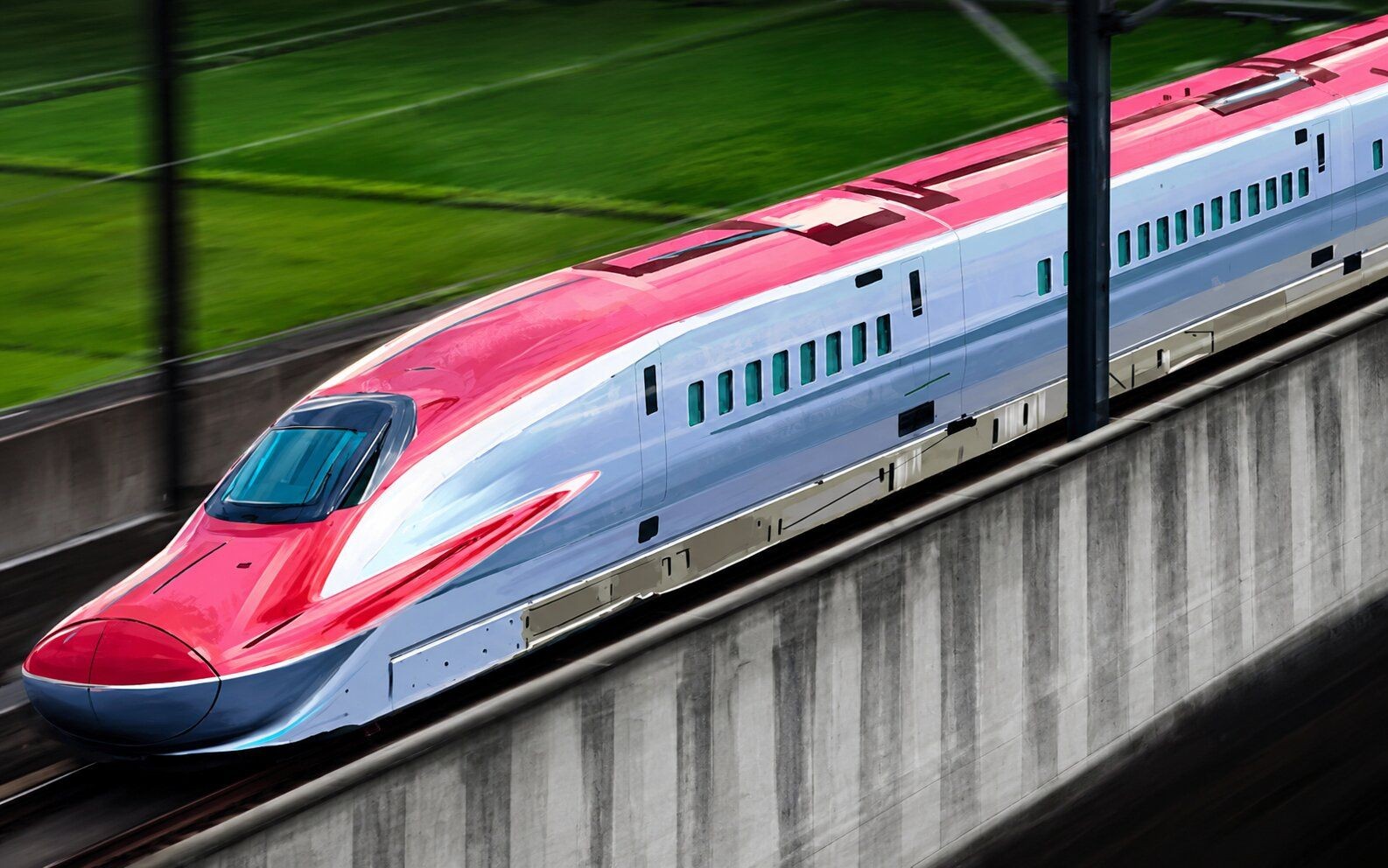 A red and silver high-speed train moves quickly on elevated tracks.