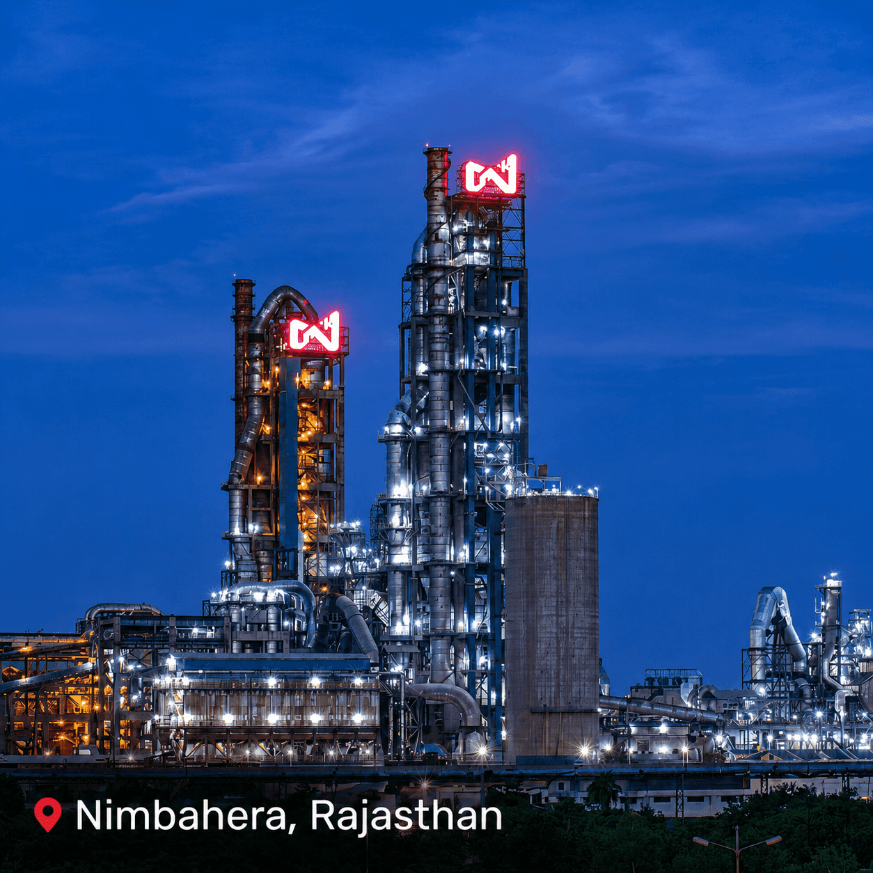 Industrial plant with glowing N2 logos and bright lights at night.